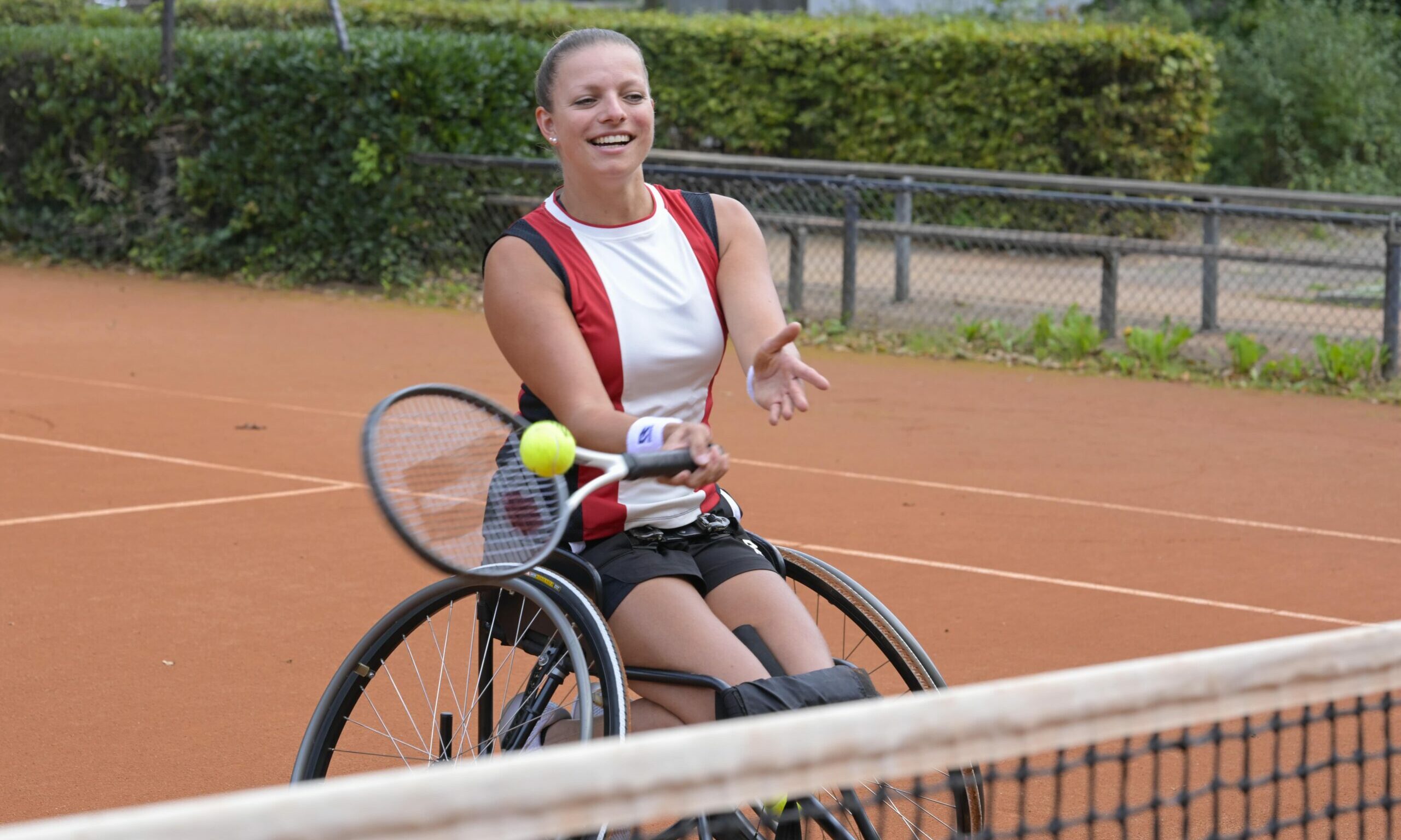 Rolstoel tennisster slaat de bal over het net